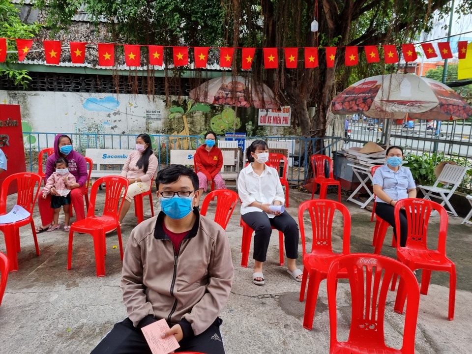 Các cử tri tổ bầu cử 248, Khu phố 4, Phường Linh Trung, Thành phố Thủ Đức, TPHCM được bố trí ngồi giãn cách trước khi vào phòng bầu cử. Ảnh Nam Dương
