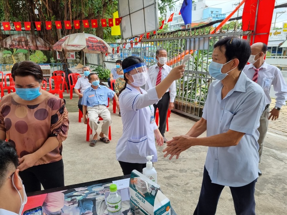 Cử tri tổ bầu cử 248, Khu phố 4, Phường Linh Trung, Thành phố Thủ Đức, TPHCM được đo thân nhiệt trước khi vào khu vực bầu cử. Ảnh Nam Dương
