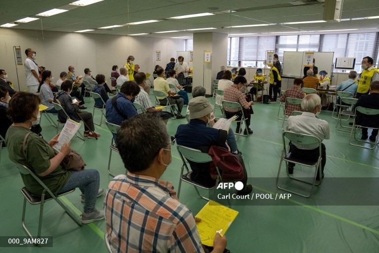 Những người Nhật Bản ngồi ngay ngắn chờ đến lượt tại một trung tâm tiêm chủng ở Tokyo ngày 24.5.2021. Ảnh: AFP