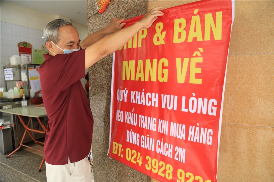 Trên phố Tống Duy Tân (Q. Hoàn Kiếm, Hà Nội) ông Hiếu đang treo thông báo “chỉ bán mang về” để chung tay chống dịch