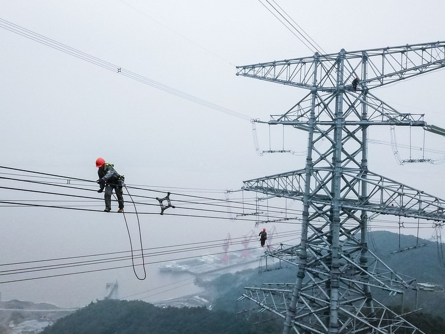 Công nhân Công ty Điện lực Chiết Giang kiểm tra các đường dây tải điện. Ảnh: Xinhua