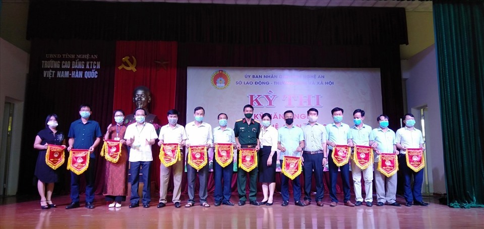 Ban tổ chức cuộc thi trao cờ lưu niệm cho các đơn vị tham gia kỳ thi Kỹ năng nghề tỉnh Nghệ An năm 2021. Ảnh: Việt Hưng
