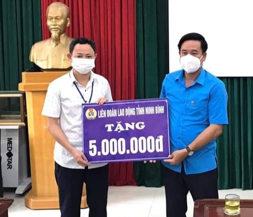 Đại diện lãnh đạo LĐLĐ tỉnh Ninh Bình trao tiền hỗ trợ các cán bộ, y bác sĩ đang làm nhiệm vụ tại Trung tâm y tế thành phố Ninh Bình. Ảnh: NT