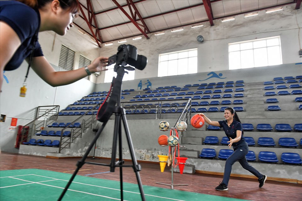 Đào Thị Hường, giáo viên thể dục gắn với với trường 8 năm nay, đang dạy kỹ thuật bóng chuyền trước máy ghi hình để gửi cho học sinh.