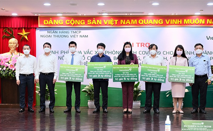Đại diện Vietcombank trao kinh phí tài trợ mua vaccine phòng COVID-19 cho các tỉnh thành phố. Ảnh: N.H