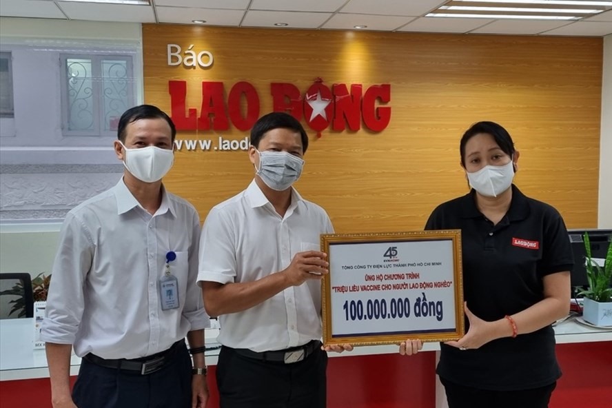 Ông Lê Văn Minh (giữa) Chủ tịch Công đoàn EVNHCMC trao 100 triệu đồng ủng hộ Chương trình “Triệu liều vaccine cho công nhân nghèo”. Ảnh Nam Dương