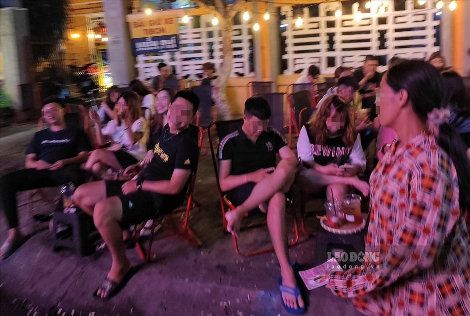 Rất đông các bạn trẻ ngồi tại các quán cà phê vỉa hè và không đeo khẩu trang tại phố đi bộ TP. Long Xuyên.