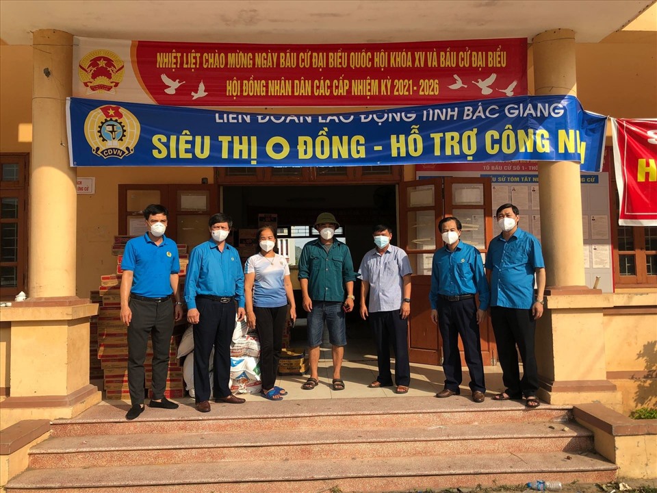 Lãnh đạo Liên đoàn Lao động tỉnh Bắc Giang chụp ảnh cùng đại diện chính quyền thôn đã vất vả chuyển đến tay công nhân lao động các gói hàng cứu trợ. Ảnh: Nguyễn Huyền