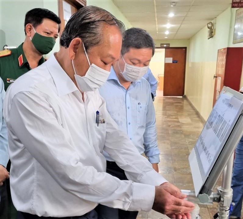 Phó Thủ tướng thường trực Chính phủ Trương Hòa Bình kiểm tra nơi rửa tay sát khuẩn trước khi vào nhà ăn của Công ty TNHH Mtex. Ảnh Chân Phúc