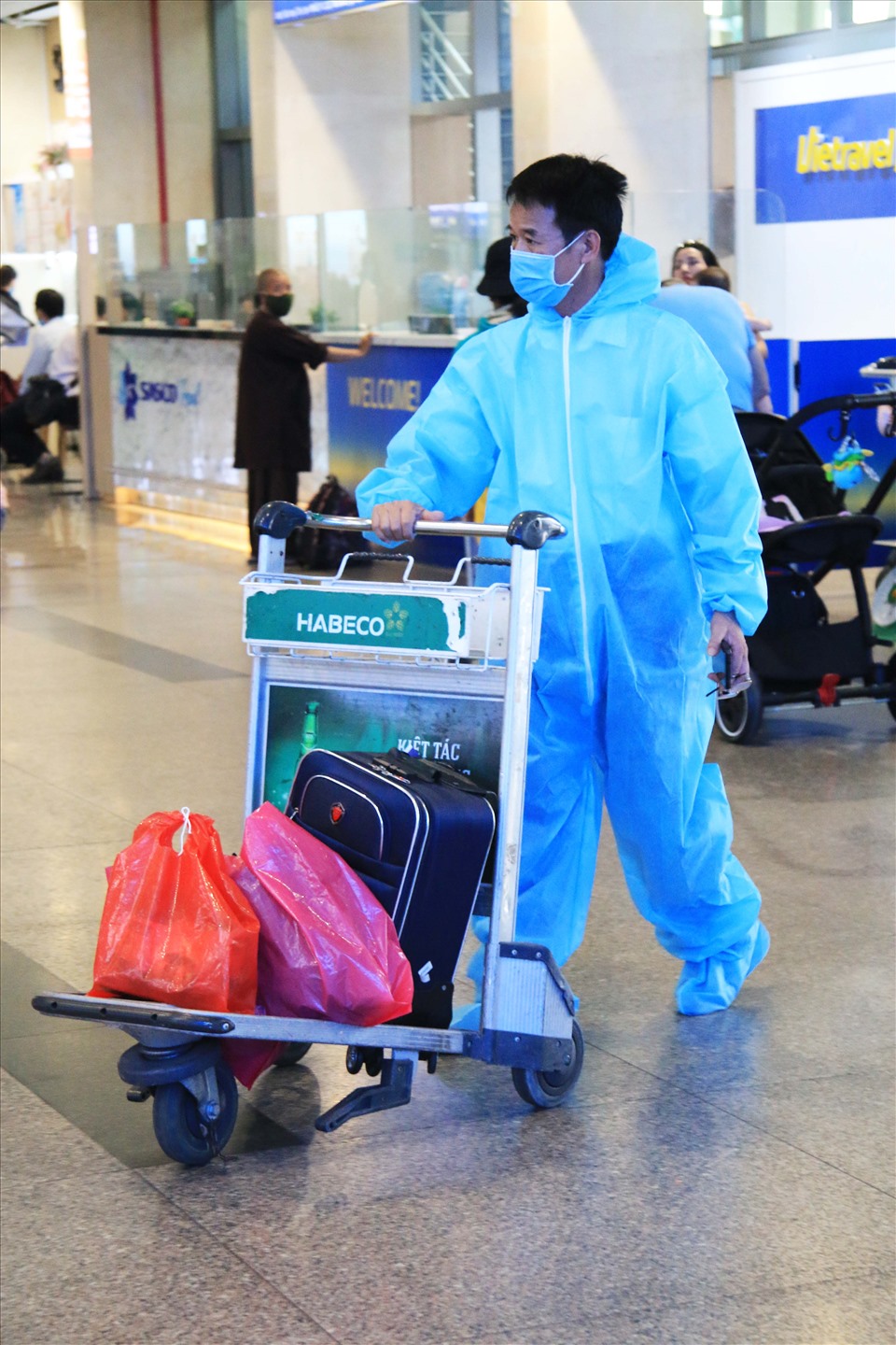 Nhiều gia đình còn cẩn thận mặc đồ bảo hộ khi tới sân bay để đảm bảo giữ an toàn phòng, chống dịch.