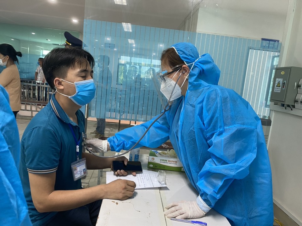 Công nhân lao động được nhân viên y tế khám trước khi tiêm vaccine COVID-19. Ảnh: Thanh Hà