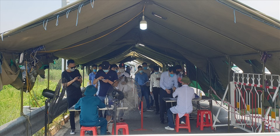 Người dân xếp hàng làm thủ tục vào Quảng Ninh tại Chốt kiểm soát liên ngành khu vực Trạm thu phí cầu Bạch Đằng trưa 1.6.2021. Ảnh: Nguyễn Hùng