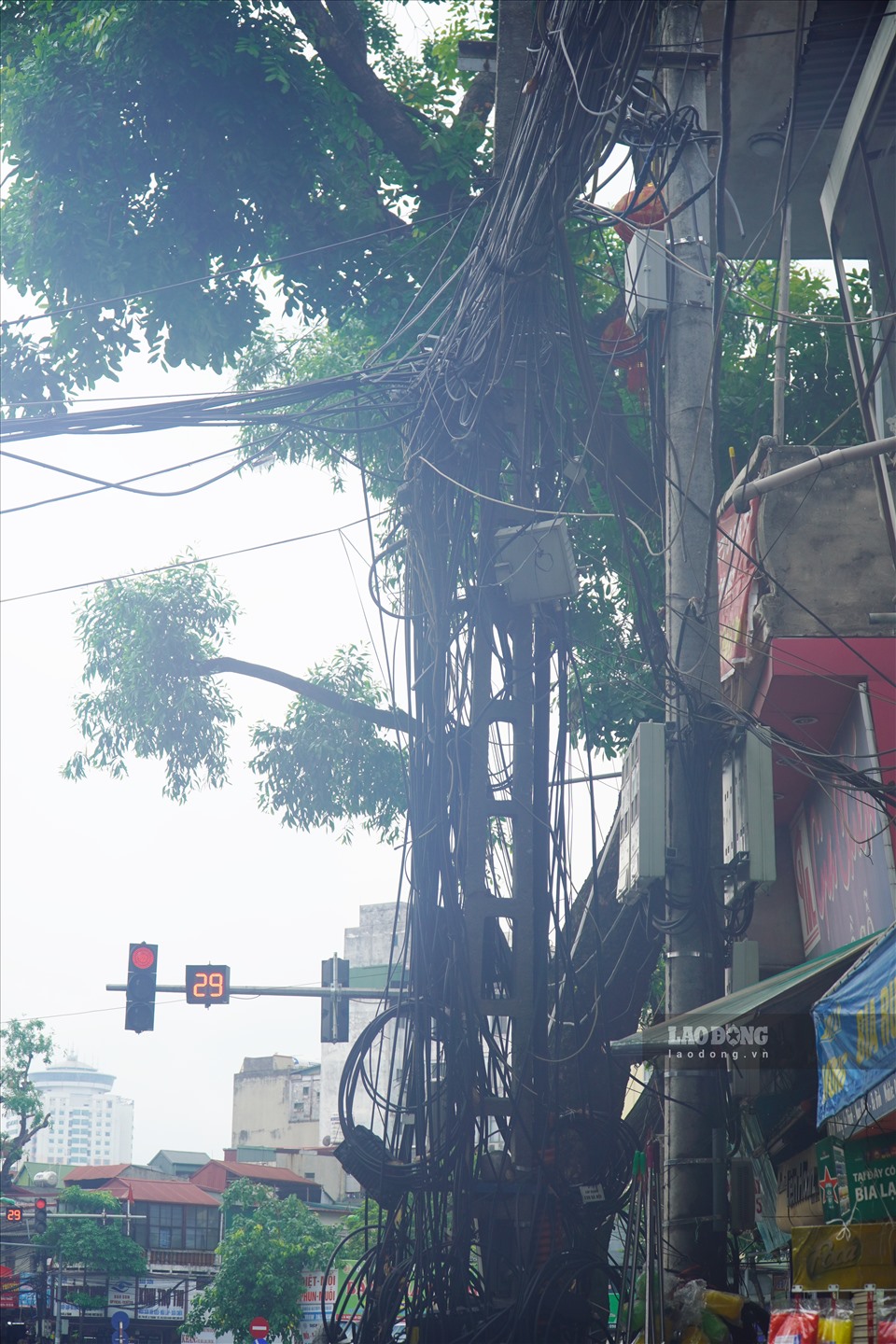 Tại tuyến phố Đê La Thành, nhiều đoạn dây rơi xuống trước cửa hàng, nhà của các hộ kinh doanh gây mất mỹ quan đô thị và nguy hiểm cho người dân.