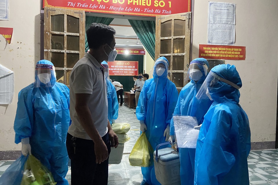 Nhân viên y tế đi lấy mẫu ở thị trấn Lộc Hà vào đêm 11.6. Ảnh: TT.