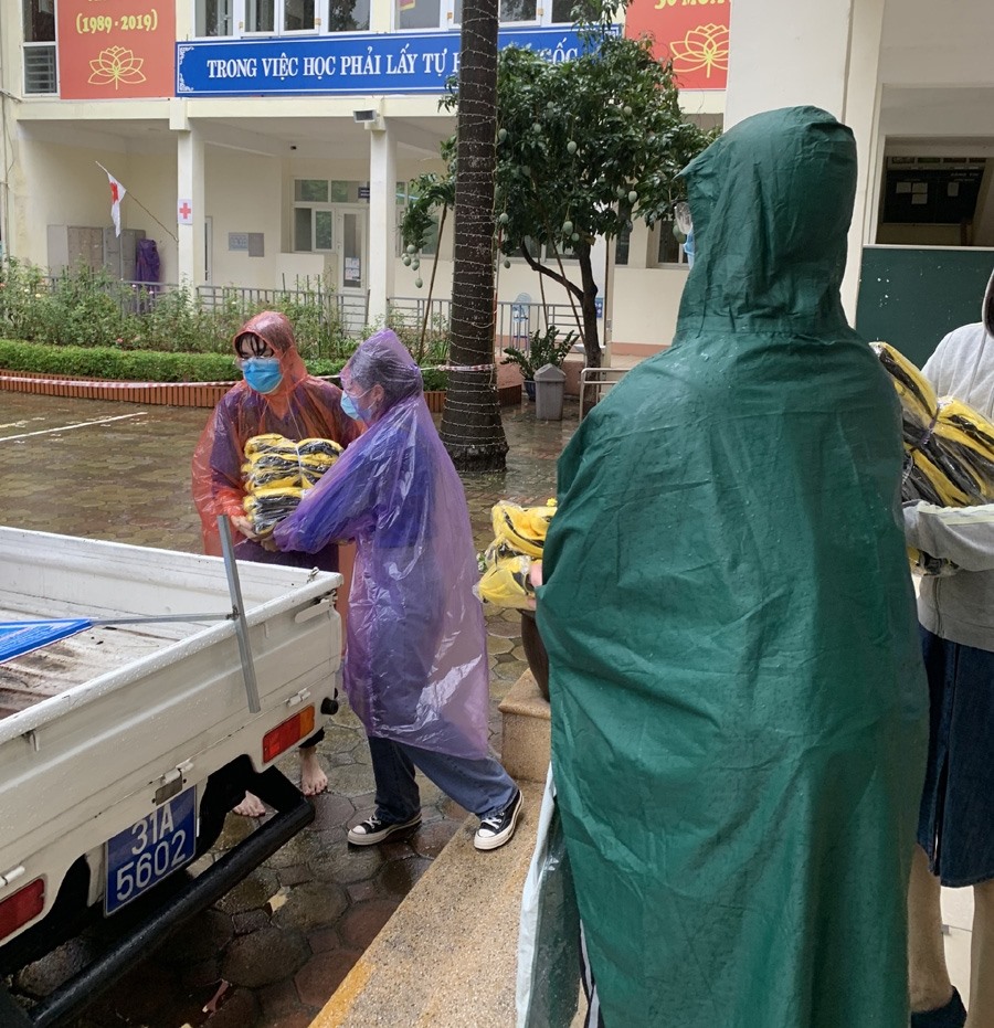 Hàng trăm bộ đồng phục thể thao được lực lượng chức năng kịp thời chuyển sang THPT Nguyễn Trãi “chi viện” cho thí sinh bị mưa ướt. Ảnh: Ngọc Minh
