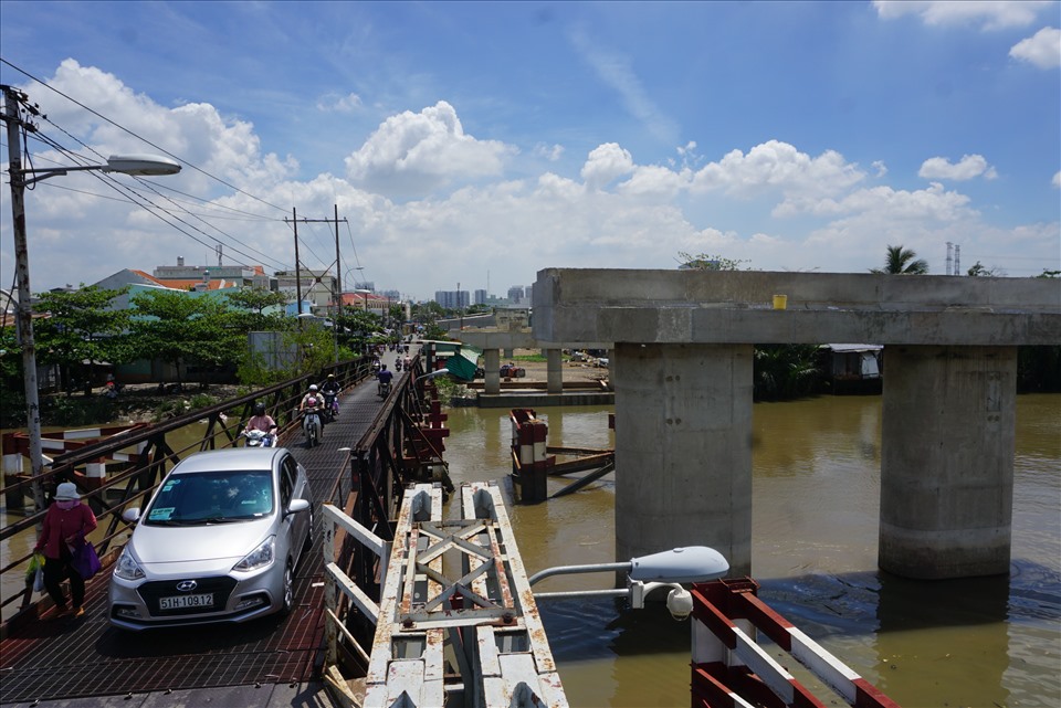 Hằng ngày người dân huyện Nhà Bè phải đi qua cầu sắt nhỏ hẹp do dự án cầu Long Kiểng mới chậm tiến độ kéo dài.  Ảnh: Minh Quân