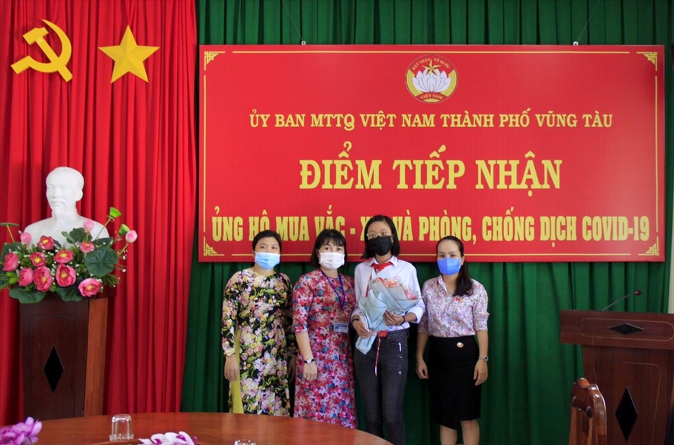 Minh Khuê được các cô chú tại Ủy ban MTTQ Việt Nam TP.Vũng Tàu tặng hoa khi quyên góp ủng hộ Quỹ vaccine COVID-19. Ảnh: T.A
