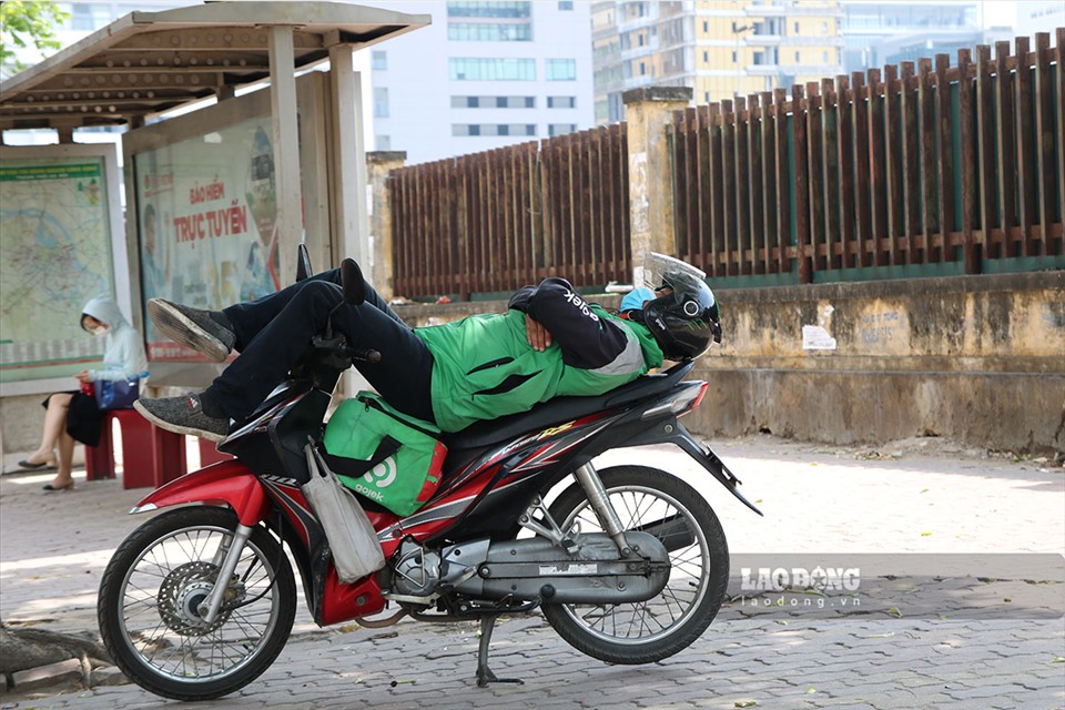 Những người làm nghề xe ôm tranh thủ ngủ trưa dưới bóng râm.