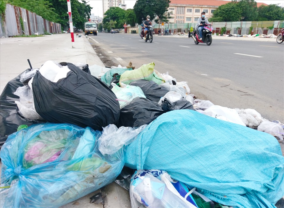 Rác chất đống trên vỉa hè và tràn cả xuống đường Nguyễn Gia Trí.   Ảnh: Minh Quân