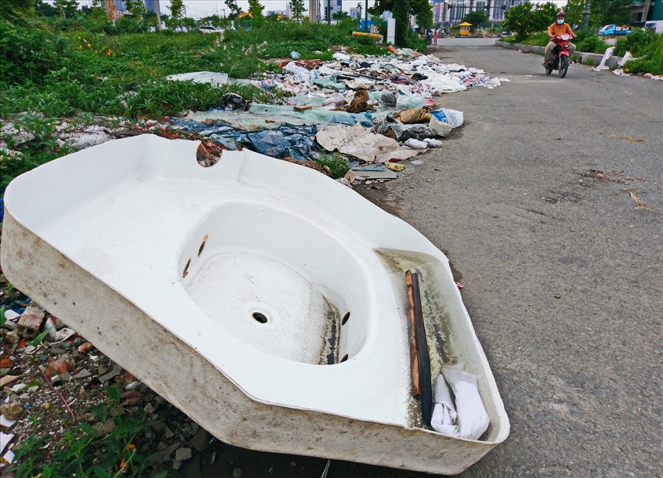 Một chiếc bồn tắm cũ bị mang vứt bỏ trên đường Trần Bạch Đằng.   Ảnh: Minh Quân