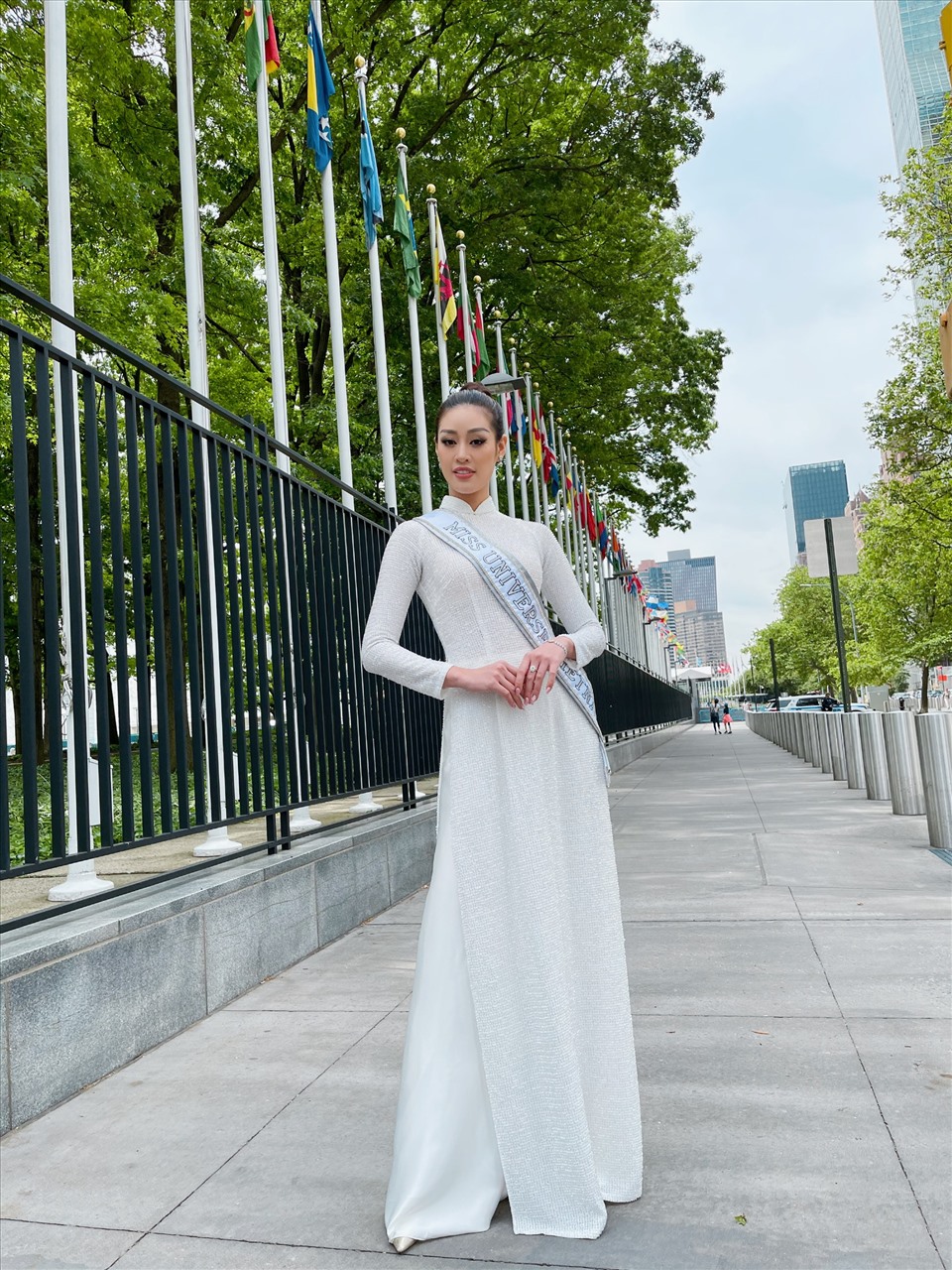 Diện chiếc áo dài trắng đơn giản, Hoa hậu Khánh Vân búi tóc cao, đeo sash Miss Universe Vietnam, tự tin thả dáng giữa đường phố New York.