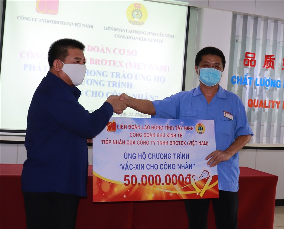 Ông Võ Văn Dũng –Chủ tịch LĐLĐ tỉnh (bìa trái) tiếp nhận bảng tượng trưng ủng hộ kinh phí 50.000.000 đồng do Ban Giám đốc Công ty TNHH Borotex VN đóng góp.