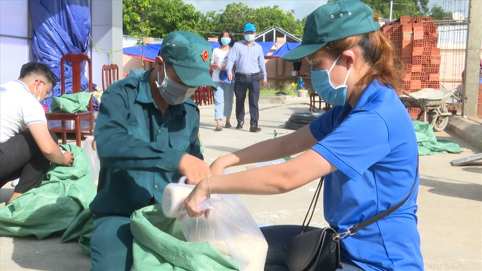 Đong sẵn gạo để phát, giảm thời gian chờ đợi nhận gạo của người dân. Ảnh: T.A