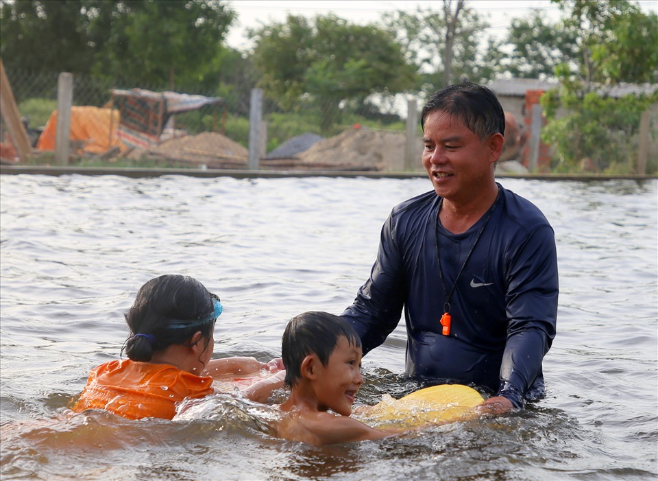 Thầy giáo Nguyễn Viết Tước dạy bơi miễn phí cho trẻ bị khuyết tật. Ảnh: Hưng Thơ.