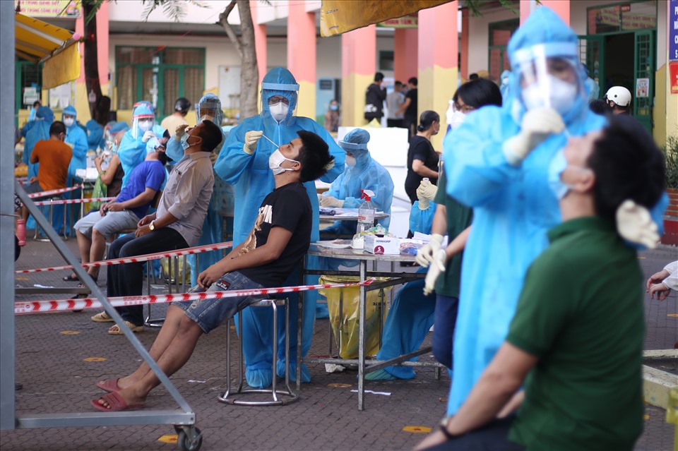 Đội ngũ y tế thuộc bệnh viện huyện Bình Chánh và bệnh viện Nhi Đồng TPHCM lấy mẫu xét nghiệm ở trường tiểu học Bình Hưng.
