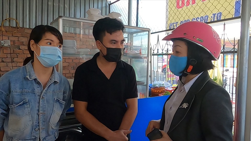 Bà Nguyễn Thu Cúc (bên phải) nhắc nhở vợ chồng quán bán đồ ăn sáng thực hiện đúng việc phòng dịch. Ảnh: Đình Trọng