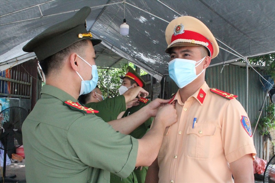 Công an huyện Lạng Giang gắn quân hàm cho đồng đội tại lán trại cạnh chốt kiểm dịch Covid xã Đại Lâm - Lạng Giang. Ảnh: PV.