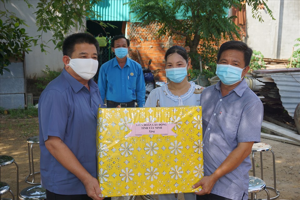 Ông Võ Văn Dũng  – Chủ tịch Liên đoàn Lao động tỉnh Tây Ninh (bìa trái) trao tặng quà chúc mừng cho vợ chồng anh Quan