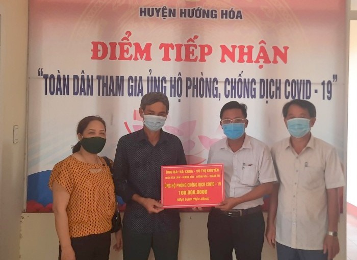 Lãnh đạo Ủy ban Mặt trận Tổ quốc Việt Nam huyện Hướng Hóa (bên phải ảnh) nhận tiền ủng hộ 100 triệu đồng của vợ chồng ông Hà Khoa. Ảnh: Văn Tư.