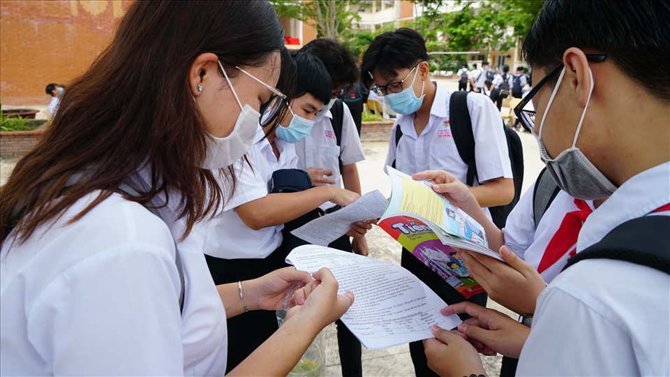 Nhiều bạn cùng nhau ôn luyện bài tập ngay cổng trường trước khi thi.