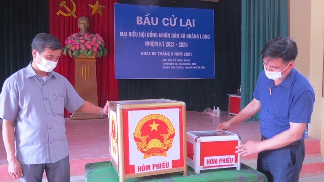 Cán bộ Ủy ban Bầu cử xã Hoàng Long kiểm tra hòm phiếu lần cuối trước ngày diễn ra bầu cử lại tại tổ bầu cử số 4, thôn Đào Xá. Ảnh Công Tâm
