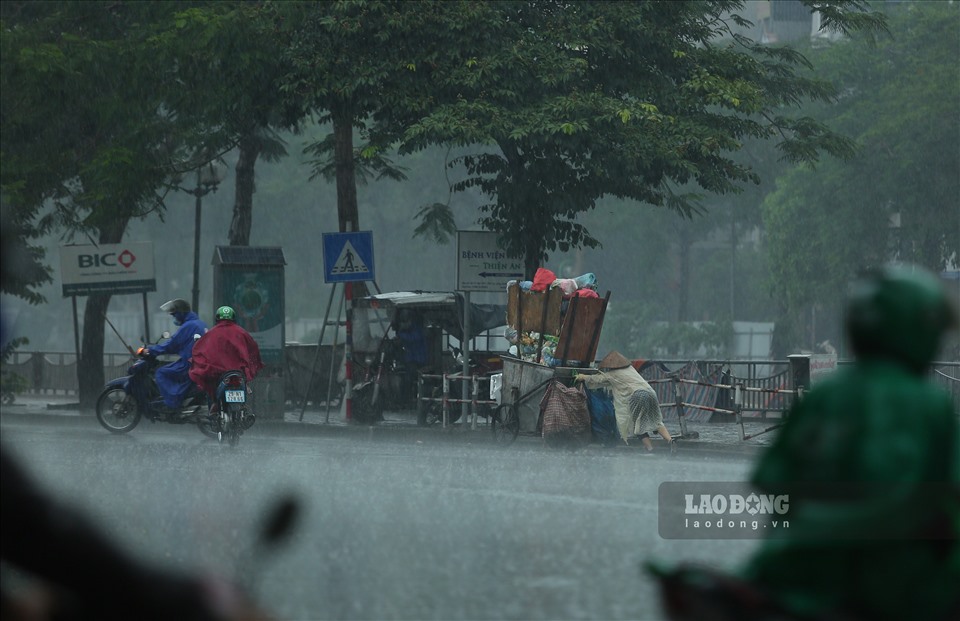 Cơn mưa lớn, nặng hạt khiến nhiều người dân di chuyển khó khăn hơn.