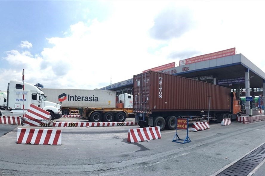 Xe container xếp hàng dài chờ qua cổng B cảng Tân Cảng - Cát Lái để lấy, xuất hàng hóa. Ảnh: Anh Tú