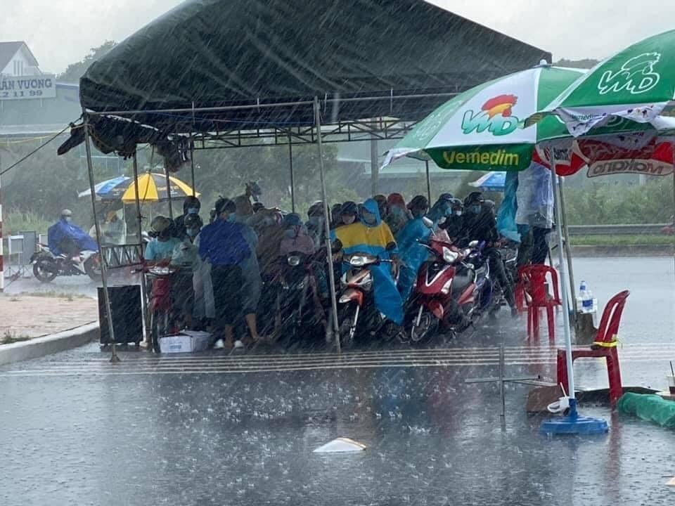Những lúc trời đổ mưa to, bạn sinh viên tình nguyện phải thêm việc vừa thực hiện công tác chống dịch, vừa căng mình giữ lều.