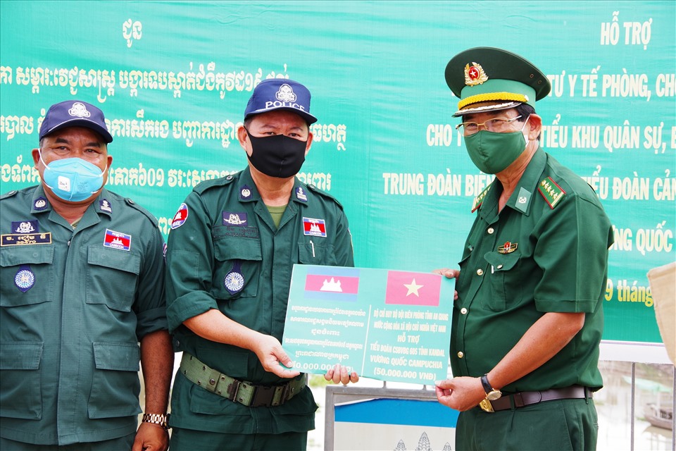 Đại tá Nguyễn Thượng Lễ, Chỉ huy trưởng Bộ đội Biên phòng tỉnh An Giang trao vật tư phòng chống COVID-19 ho lực lượng bảo vệ biên giới Campuchia tại cầu Long Bình, huyện An Phú. Ảnh: CK