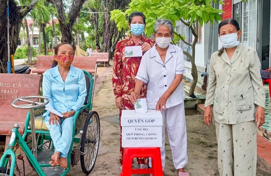 Những cụ già tại Trung tâm Bảo trợ xã hội tỉnh Cà Mau đóng góp tiền ủng hộ chương trình phòng chống COVID-19. Ảnh: Nhật Hồ