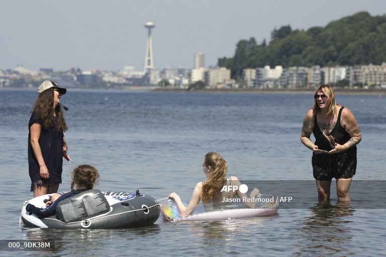 10. Tracy Werthman (L) và Nikoma Echt, cả hai ở Tây Seattle, và con cái của họ tắm mát tại Bãi biển Alki khi cảnh báo nhiệt độ quá cao vẫn có hiệu lực một ngày sau khi nhiệt độ kỷ lục chạm vào khu vực ở Seattle, Washington vào ngày 29 tháng 6 năm 2021.