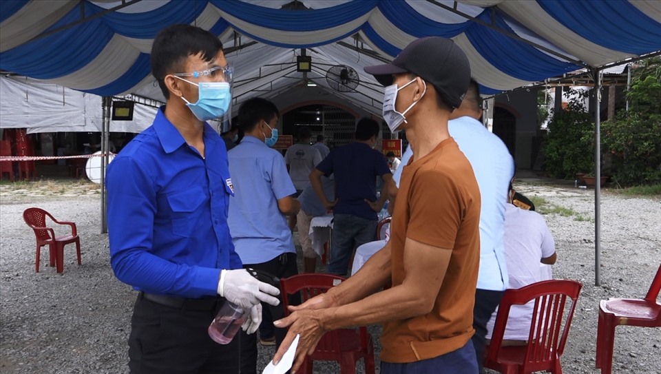 Đoàn viên Thanh niên xịt khử khuẩn cho các tài xế tại khu vực khai báo y tế. Ảnh: Phạm Duy