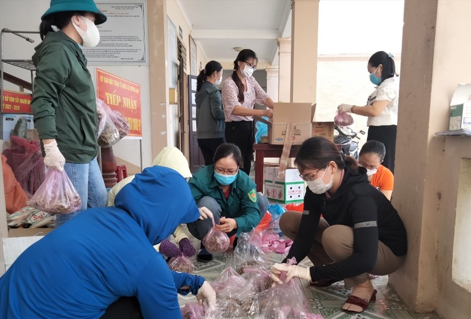 Cán bộ và người dân Quỳnh Lâm chuẩn bị các suất cơm hỗ trợ chống dịch COVID-19. Ảnh: NK