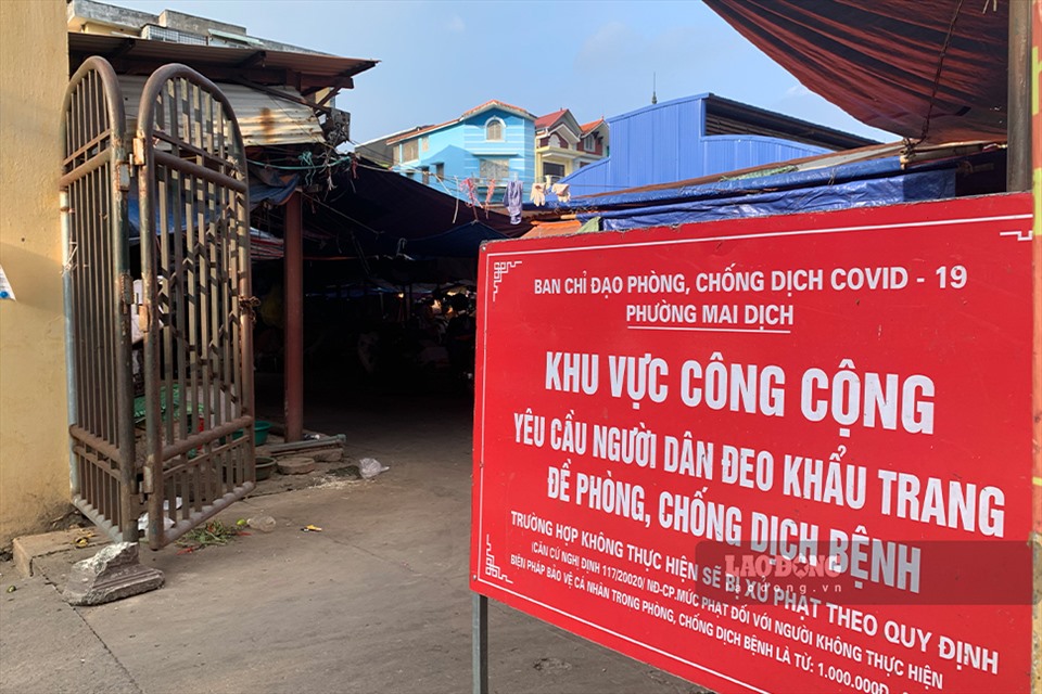Tấm biển thông báo lớn về yêu cầu tuân thủ các quy định phòng dịch COVID-19 được đặt ngay trước lối ra vào cổng chợ Đồng Xa (phường Mai Dịch, quận Cầu Giấy, Hà Nội).