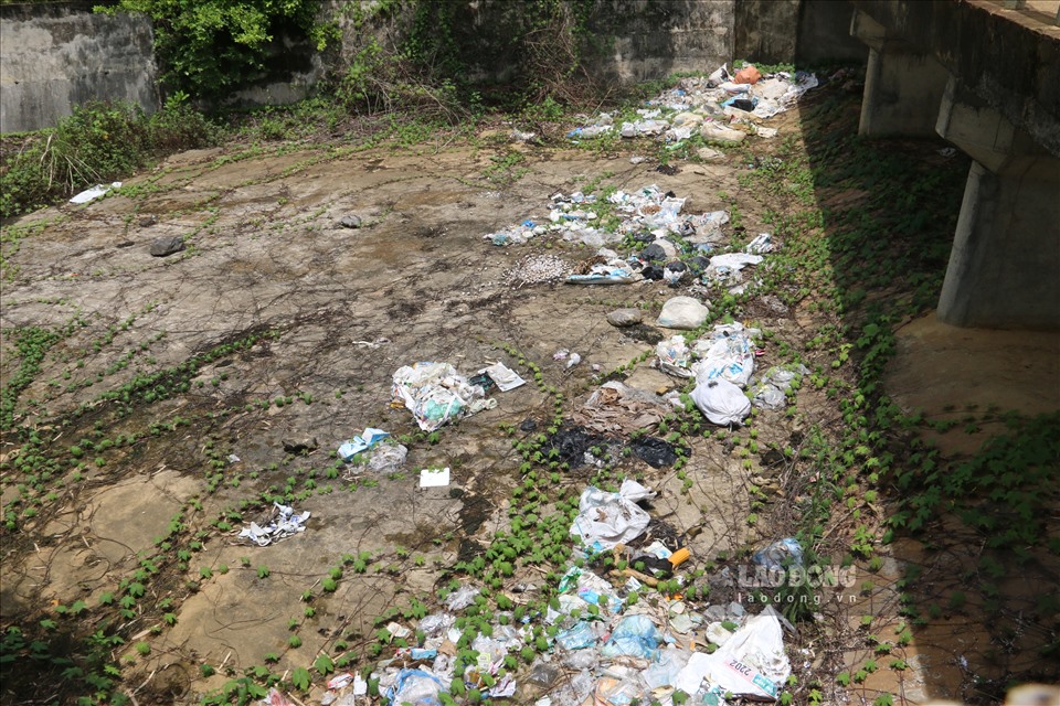Xung quanh đập tràn của hồ là những túi rác người dân “tiện tay” ném xuống khiến cho nguồn nước bị ô nhiễm.