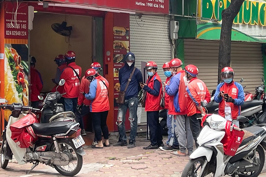 Tại một cửa hàng bánh mì trên phố Tô Hiệu, shipper xếp hàng dài để nhận đồ.