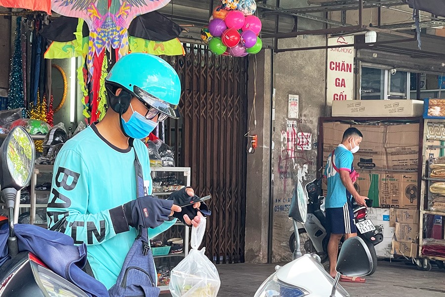 Một shipper check lại đơn hàng trước khi giao cho khách.