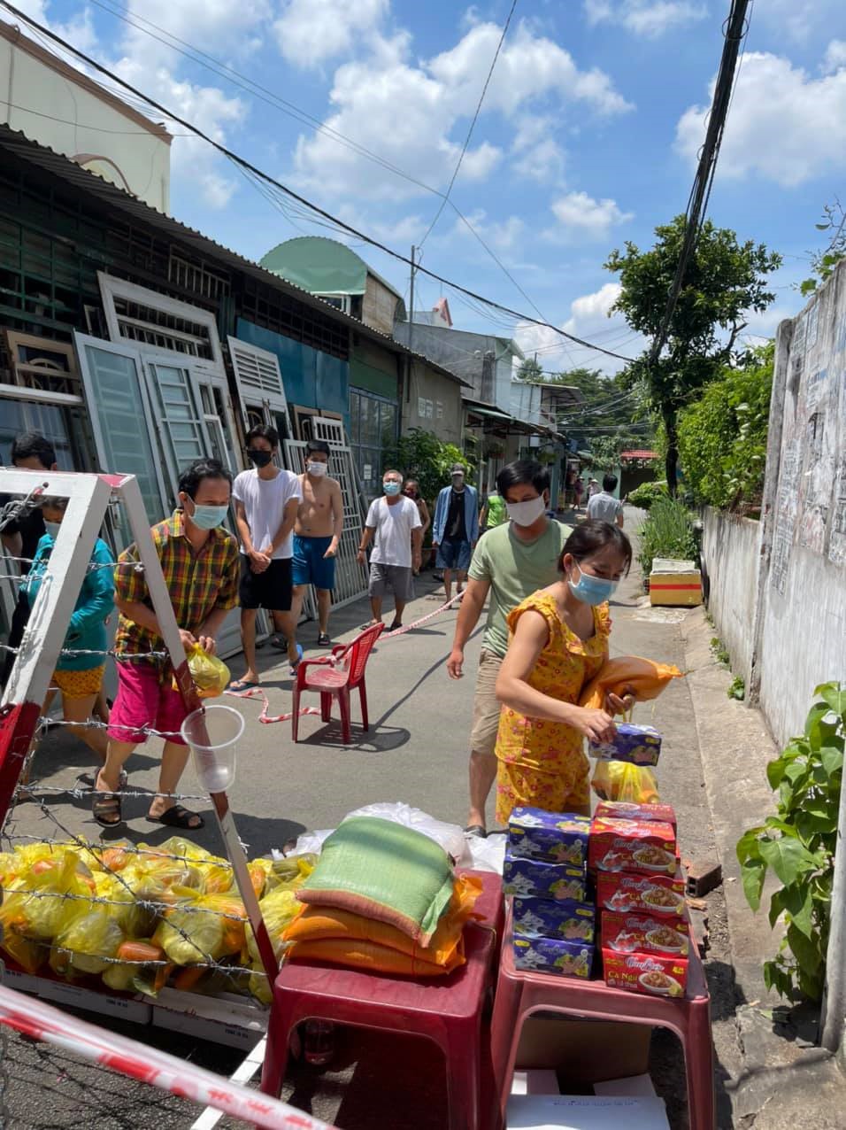 Đại diện nam ca sĩ đi phát quà cho người dân. Ảnh: NSCC.