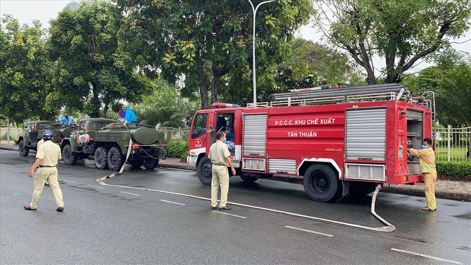 Xe phòng cháy chữa cháy của Khu chế xuất Tân Thuận cấp nước cho các xe của lực lượng hóa học Quân Khu 7 phun khử khuẩn. Ảnh Đức Long