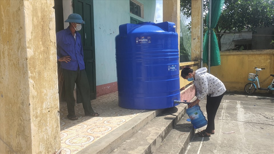 Người dân lấy nước sạch tiếp tế ở nhà văn hóa thôn Thanh Mai. Ảnh: T.D
